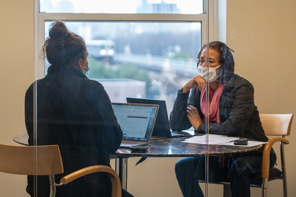 Journalism professor Judith McCray meets with a student in a conference room.