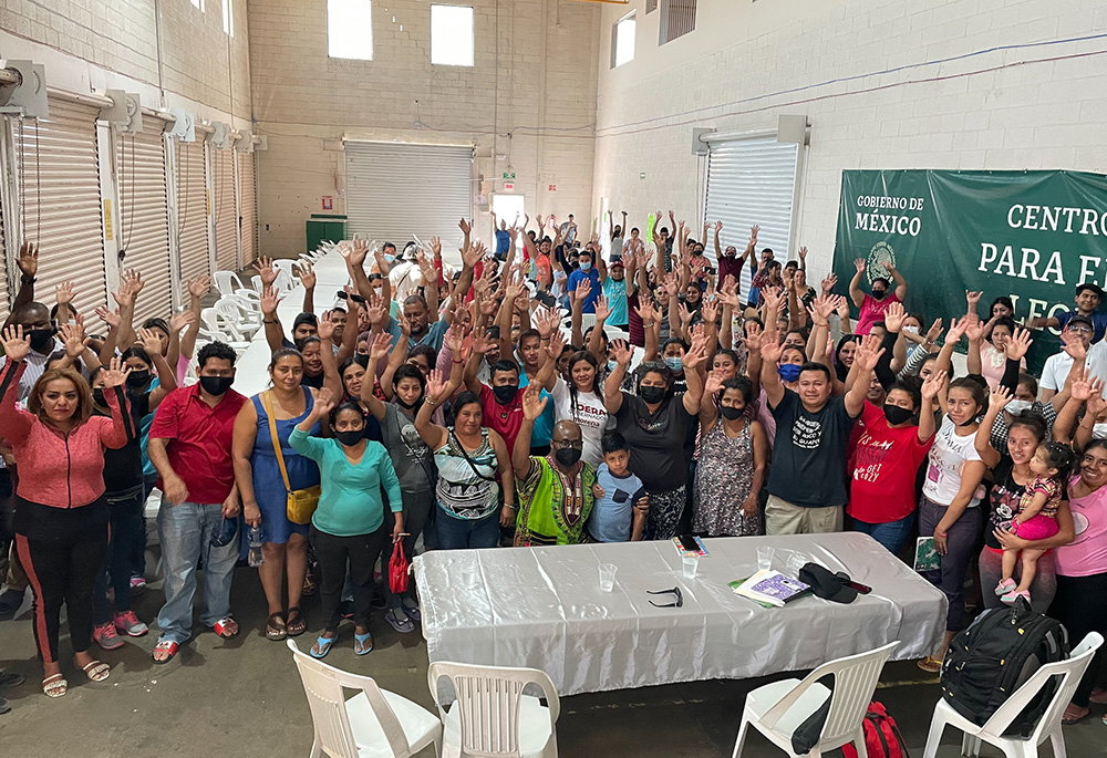 Fr. Stan Chu Ilo, center, wearing green, poses with people at a holding center for migrants in Ciudad Juarez, Mexico. Ilo and others interviewed the people at the center for the Vatican's 
