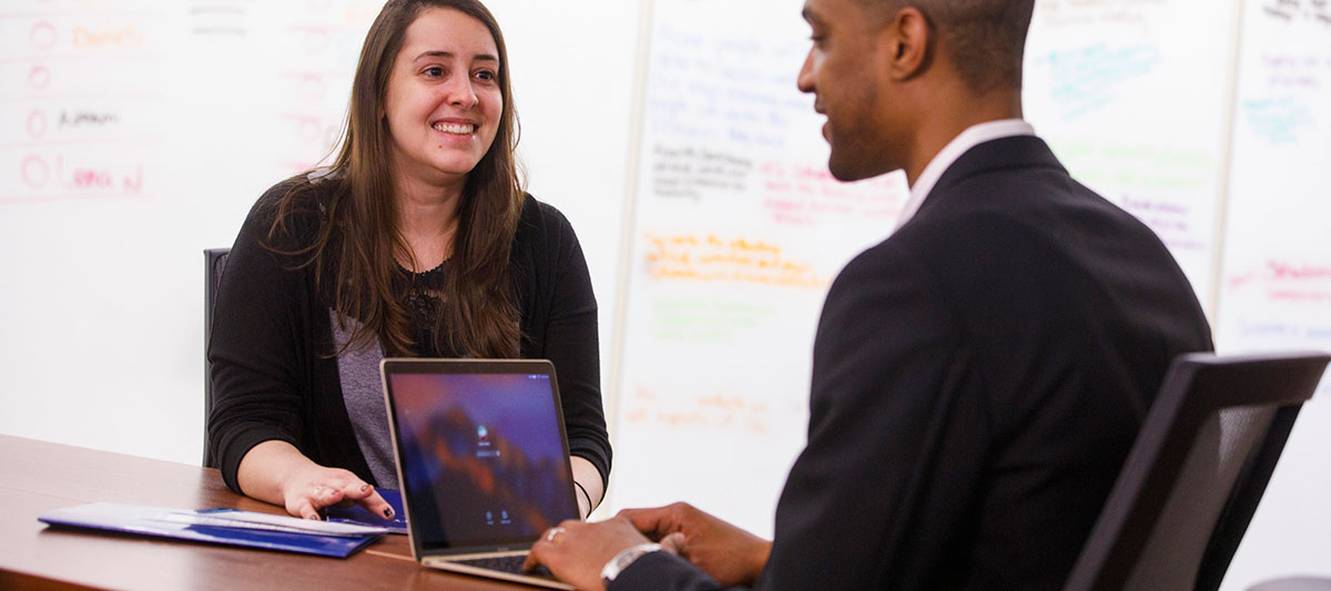 Image of students talking with computer between them