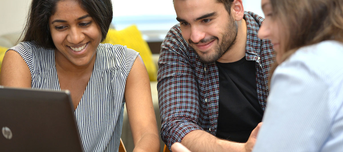 Students looking at a computer laptop together