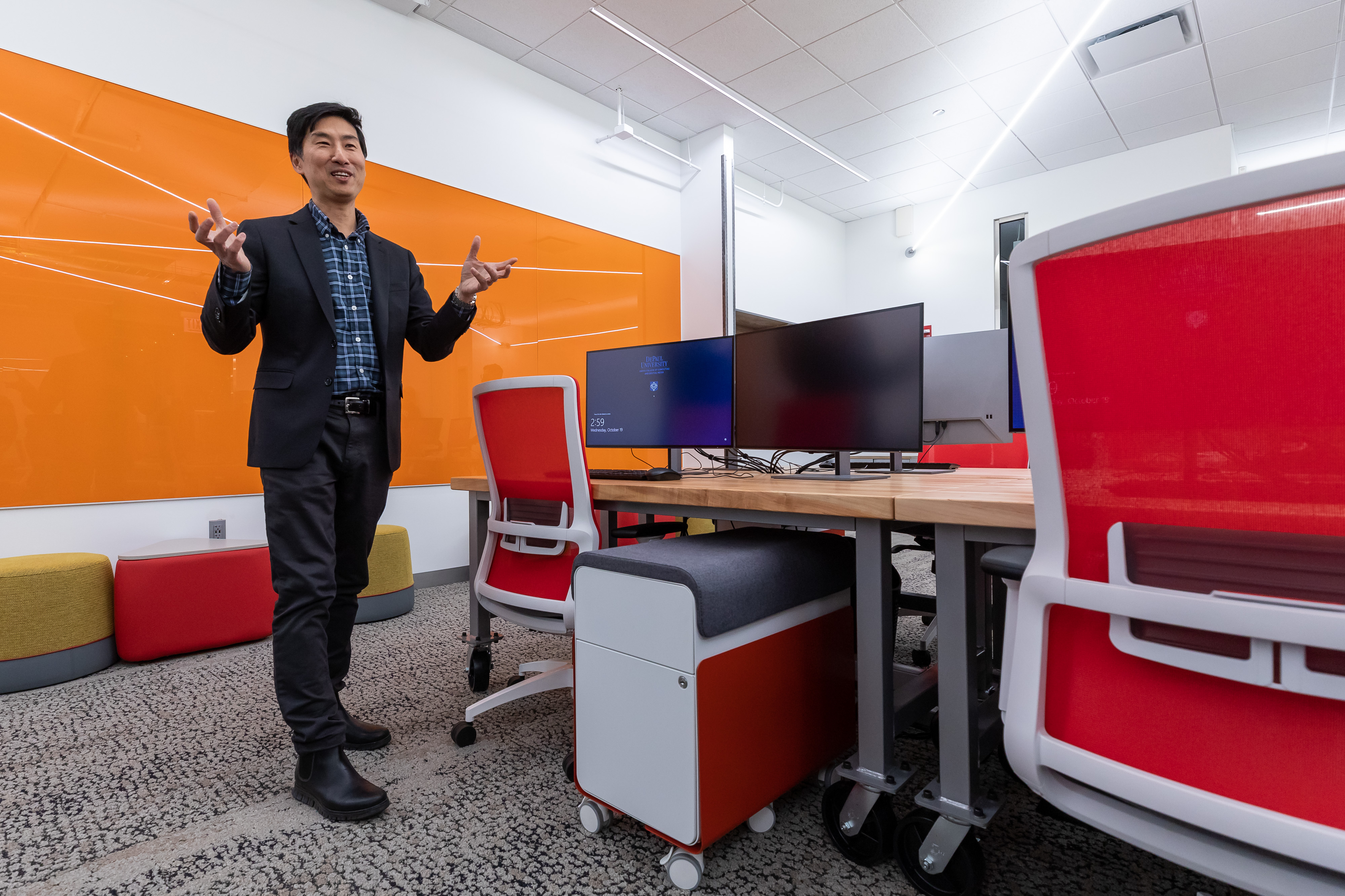 Josh Tsui in colorful red and orange space at Jarvis Student Center for Innovation and Collaboration