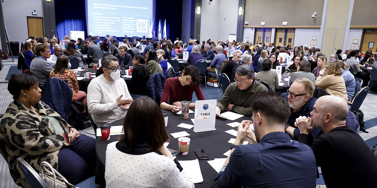 Tables of ten people in a large auditorium
