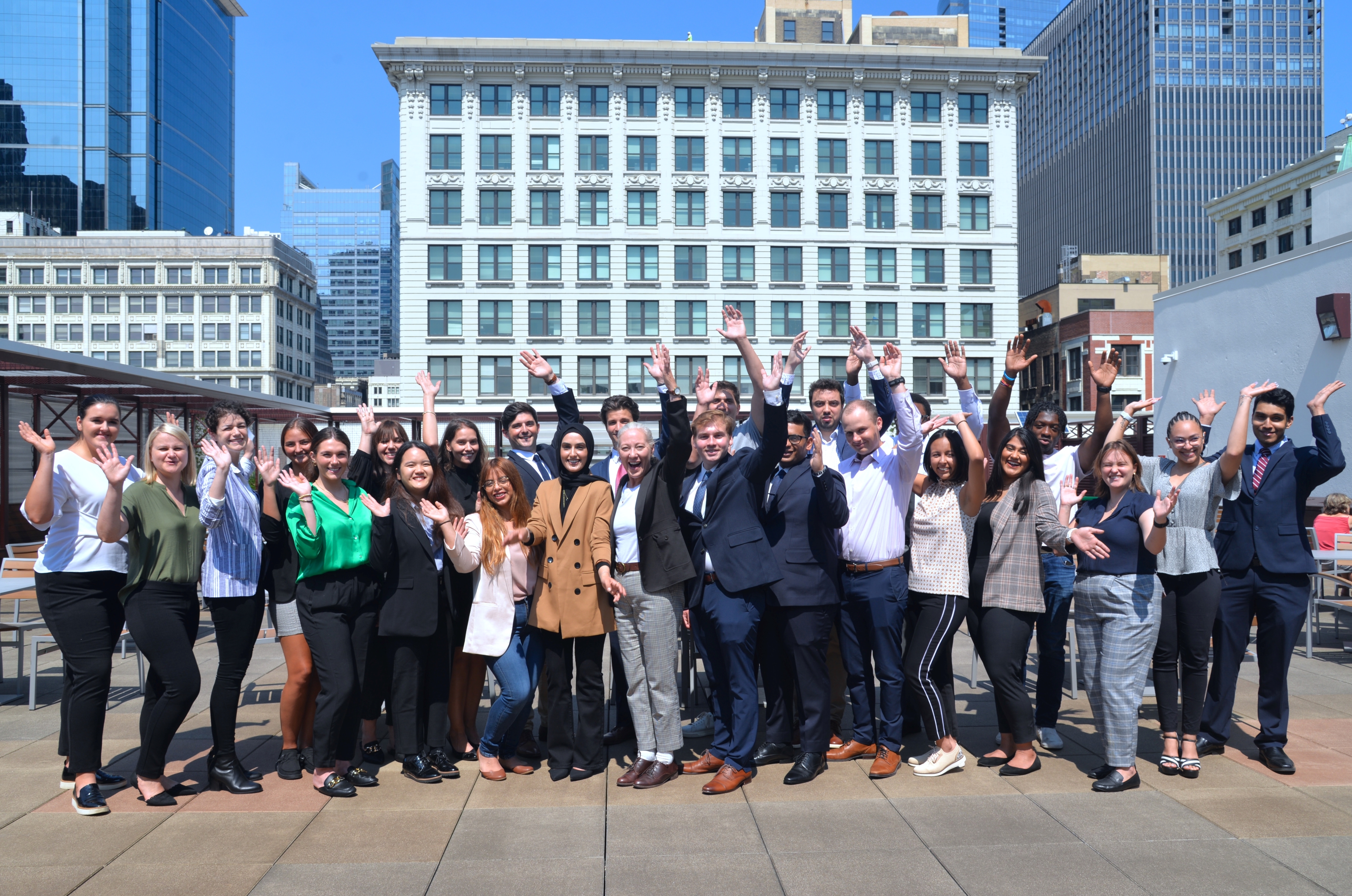 A group of about 50 students strike a celebratory pose
