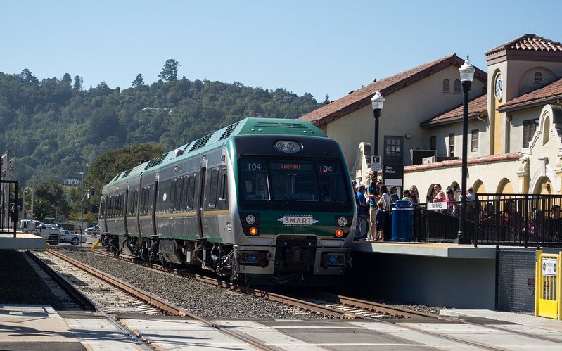 green train pulls up to station