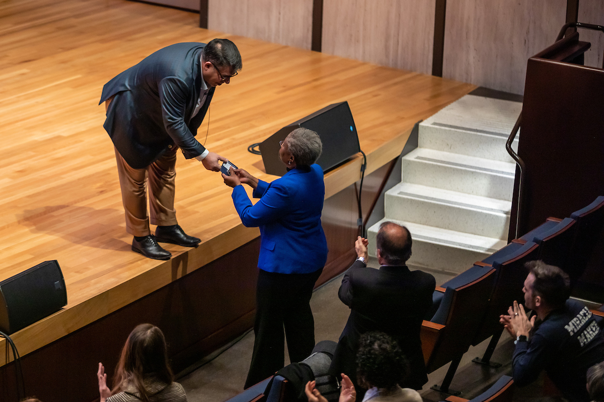 Rob Manuel hands a Shared Coin to Valerie Johnson.