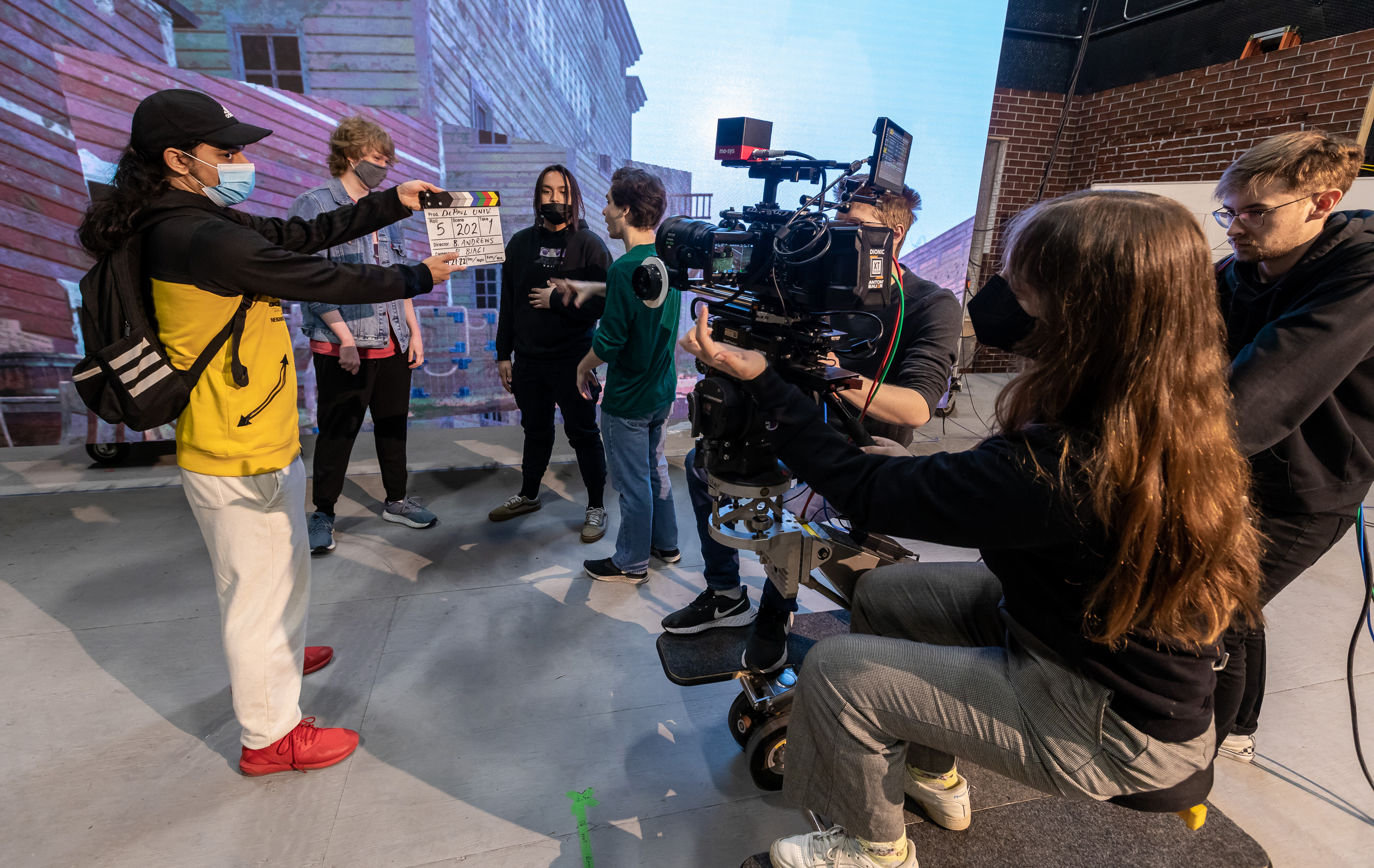 Students with a camera work in front of the LED screens for virtual production
