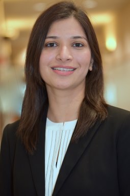 Khadija Ali Vakeel, a young Indian woman, smiles in a fashionable suit
