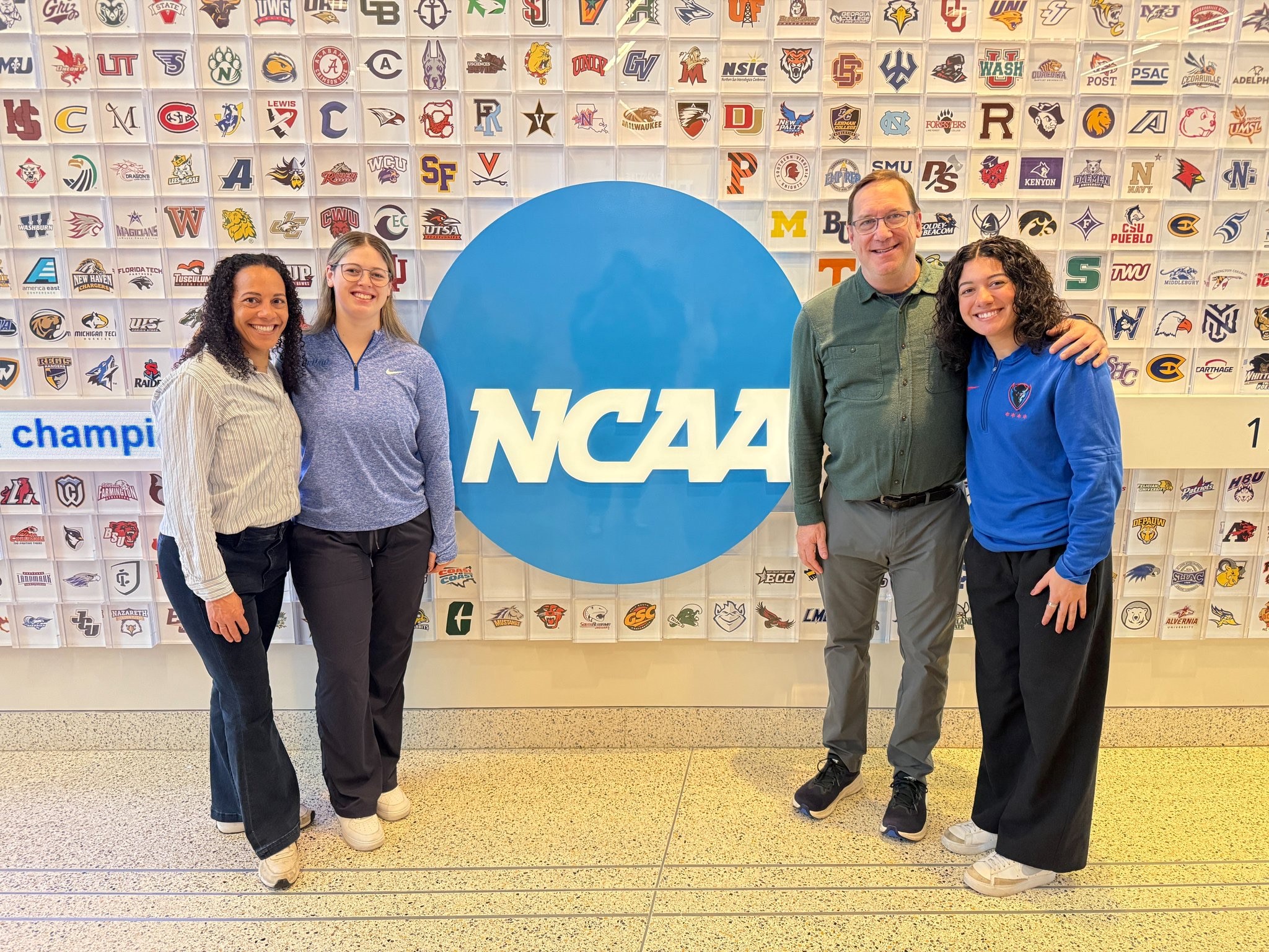 DePaul community members in front of NCAA logo in Indianapolis.