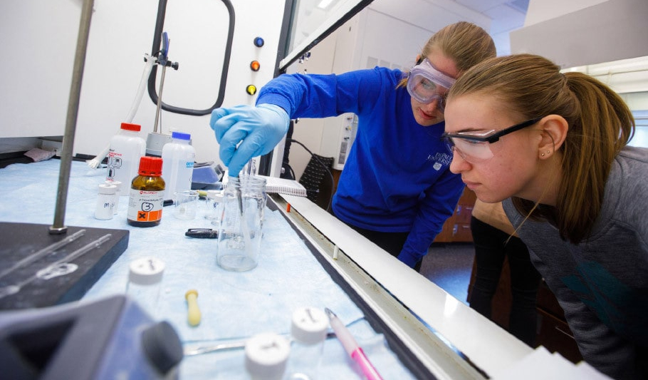 Two students testing samples in a lab.