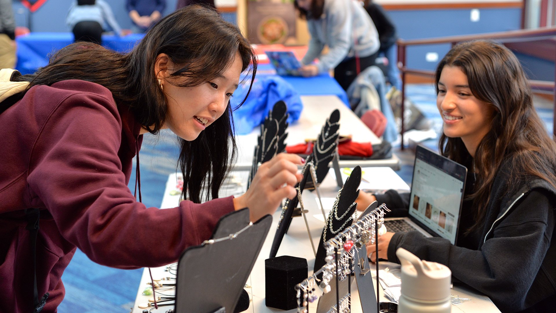 A DePaul student admires jewelry at the Coleman Center's Welcome Back Market.
