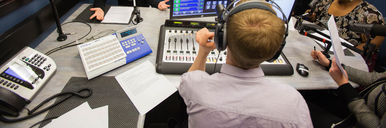 Five people seated inside a Radio DePaul recording studio