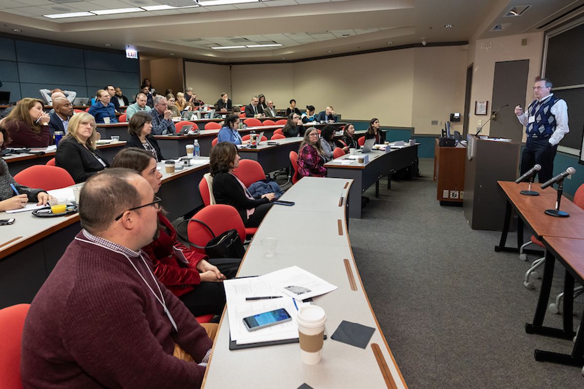 Phillip Funk presents to an auditorium of attendees