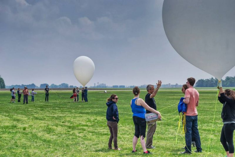 A group of students experimenting with large balloons in a field.