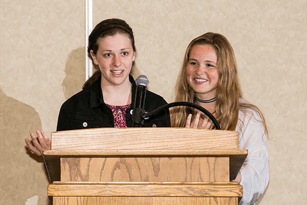 Two women speaking at a podium