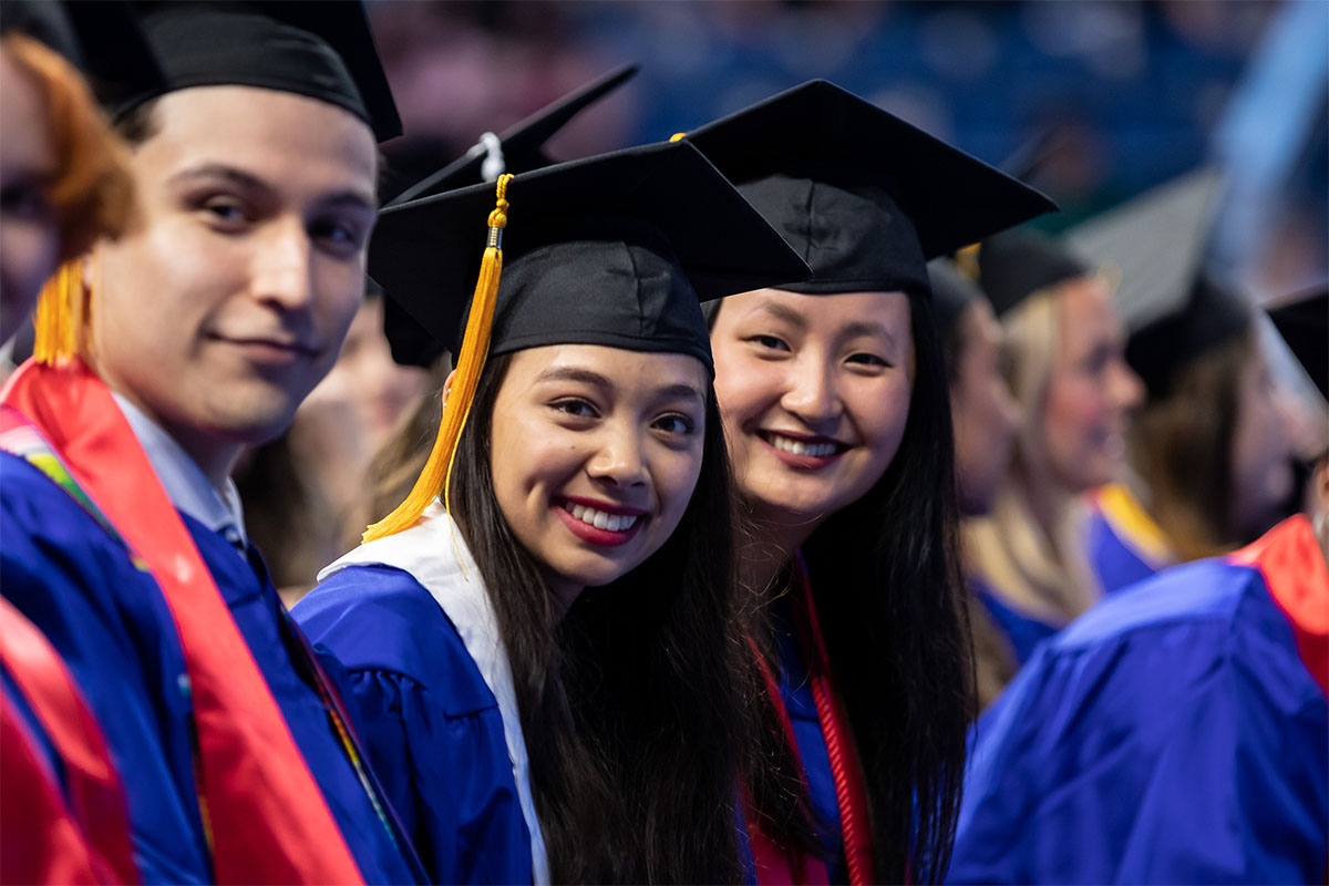 Three graduates pose for the camera