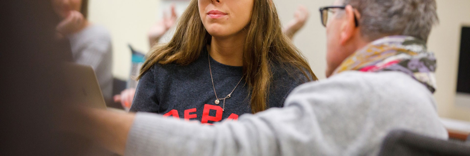 Woman wearing a Cubs baseball cap in a classroom