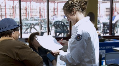 A student speaking with members of the community.