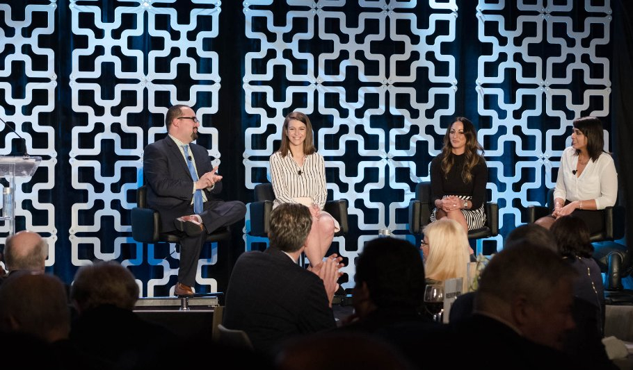 Four people seated on stage mid-conversation