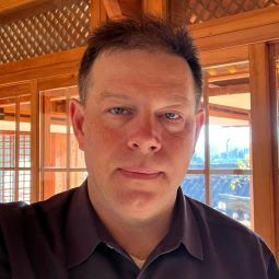 Eric Landahl, a middle aged white man, in a home with light-filled windows in the background 