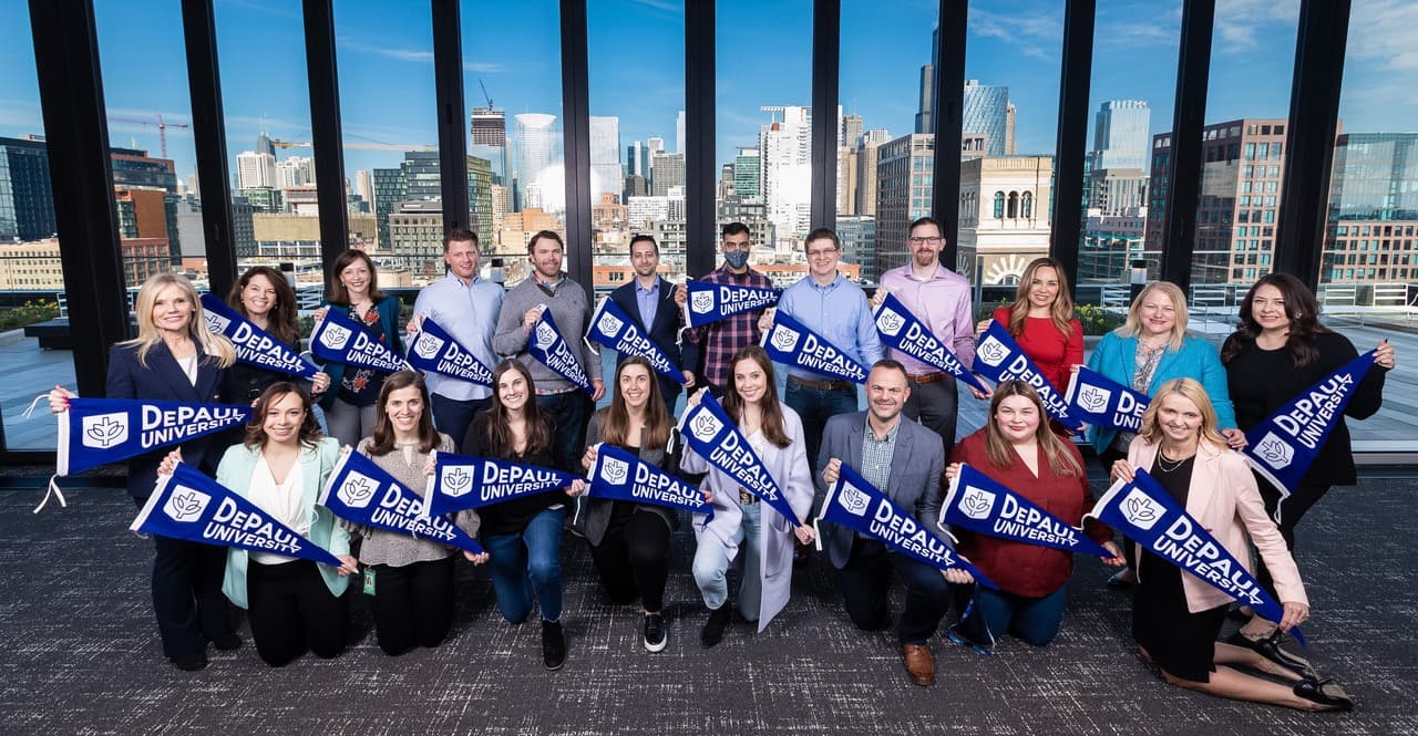 Group of students holding DePaul University flags