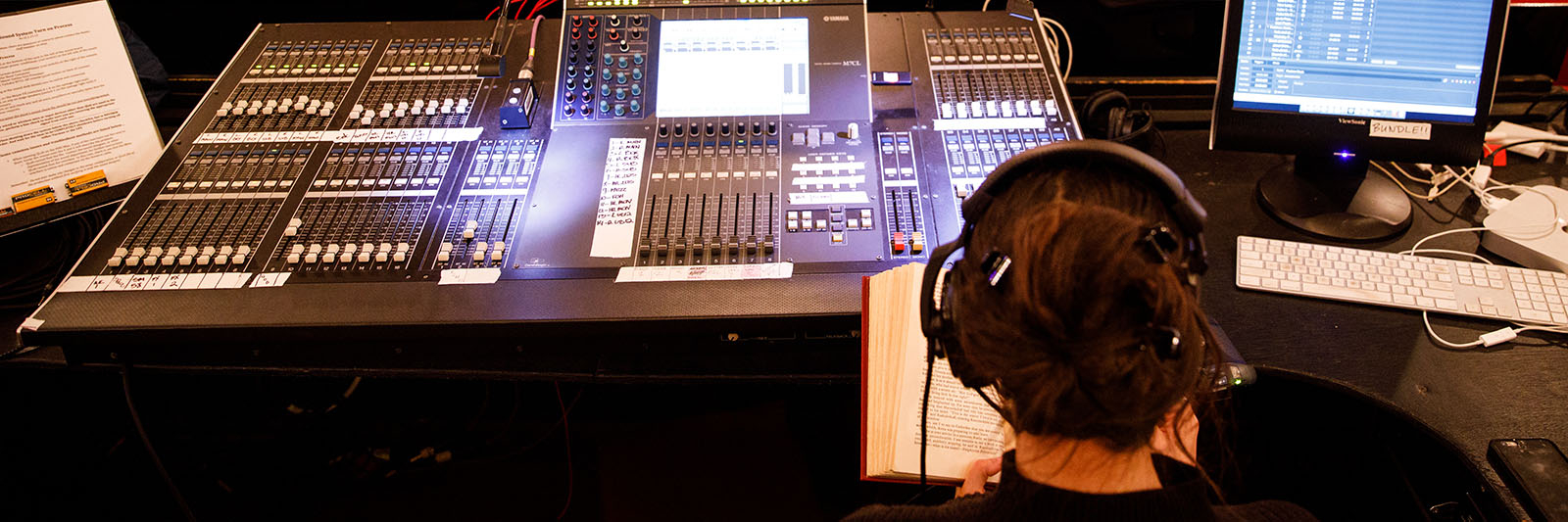 A Sound Design student works the sound board during a production.