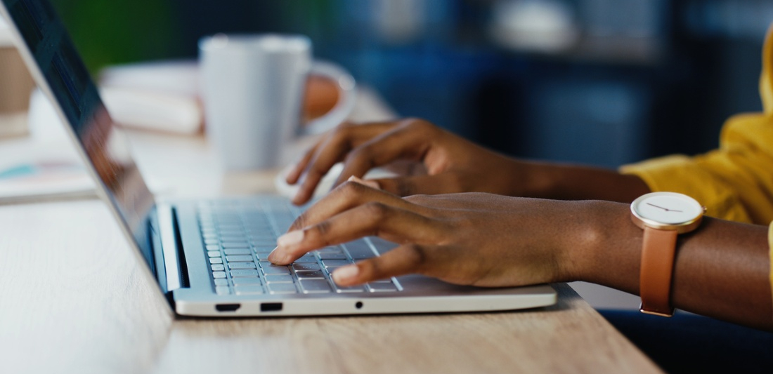 Hands typing on a laptop computer