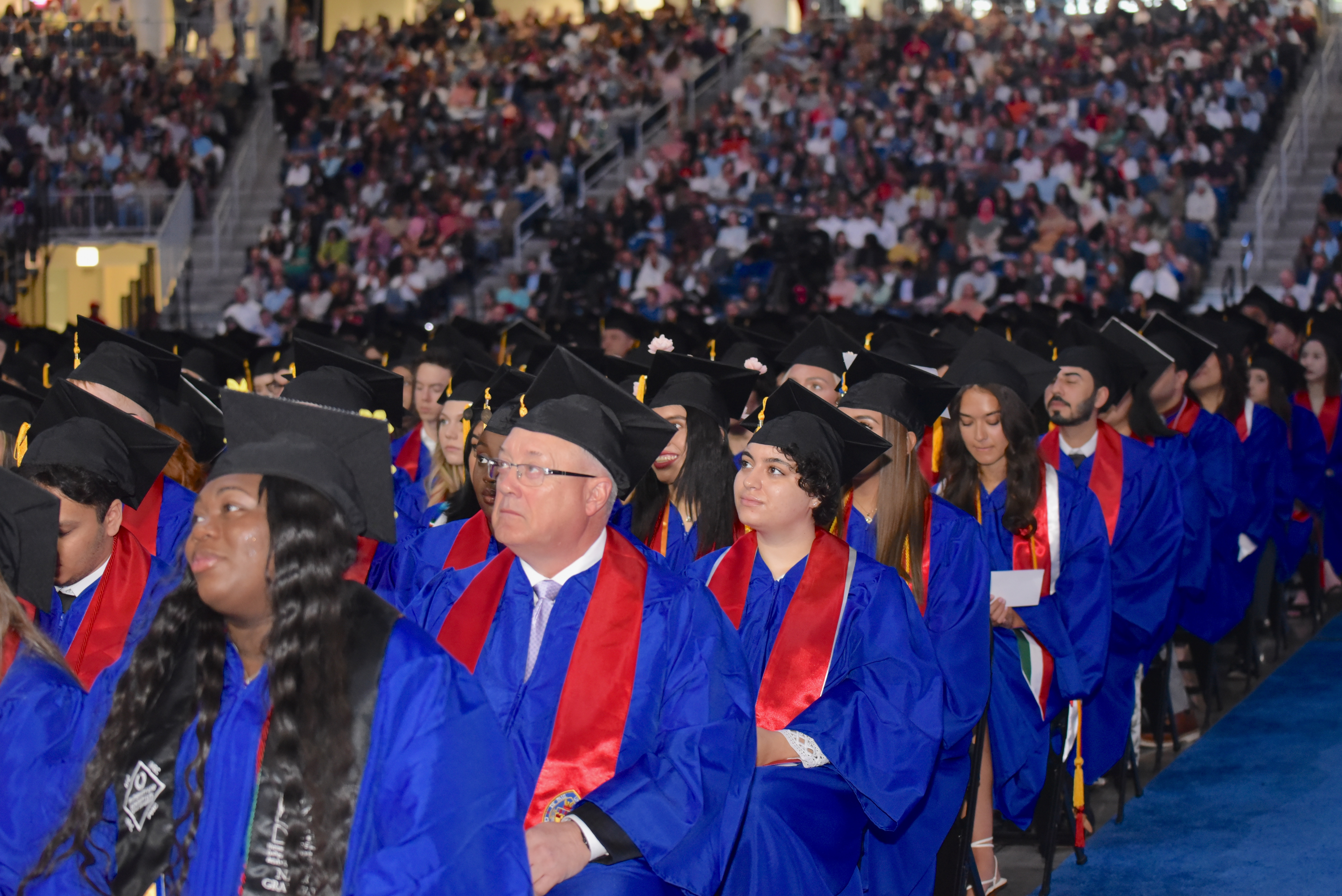 A group of graduate in bright blue robes and graduation caps