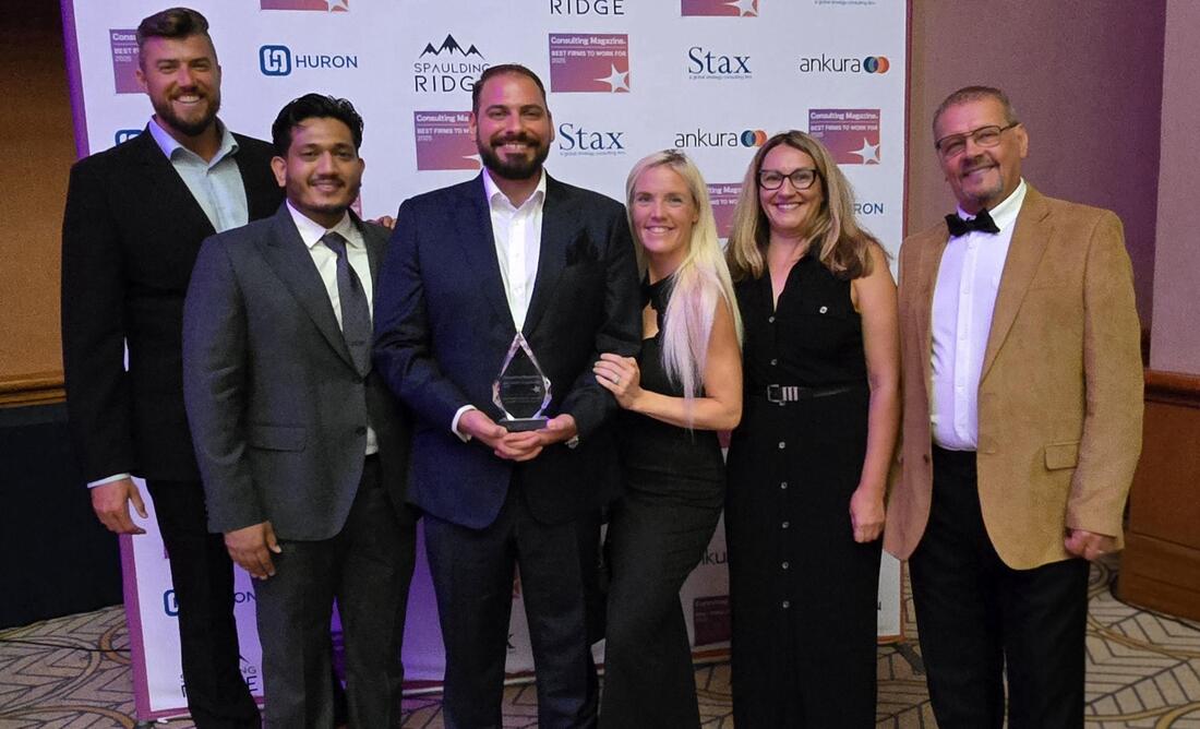 A team of professionals, including Goran Gmitrovic, pose with a glass award