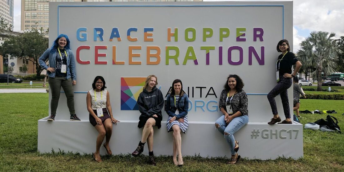 students in front of Grace Hopper Celebration sign