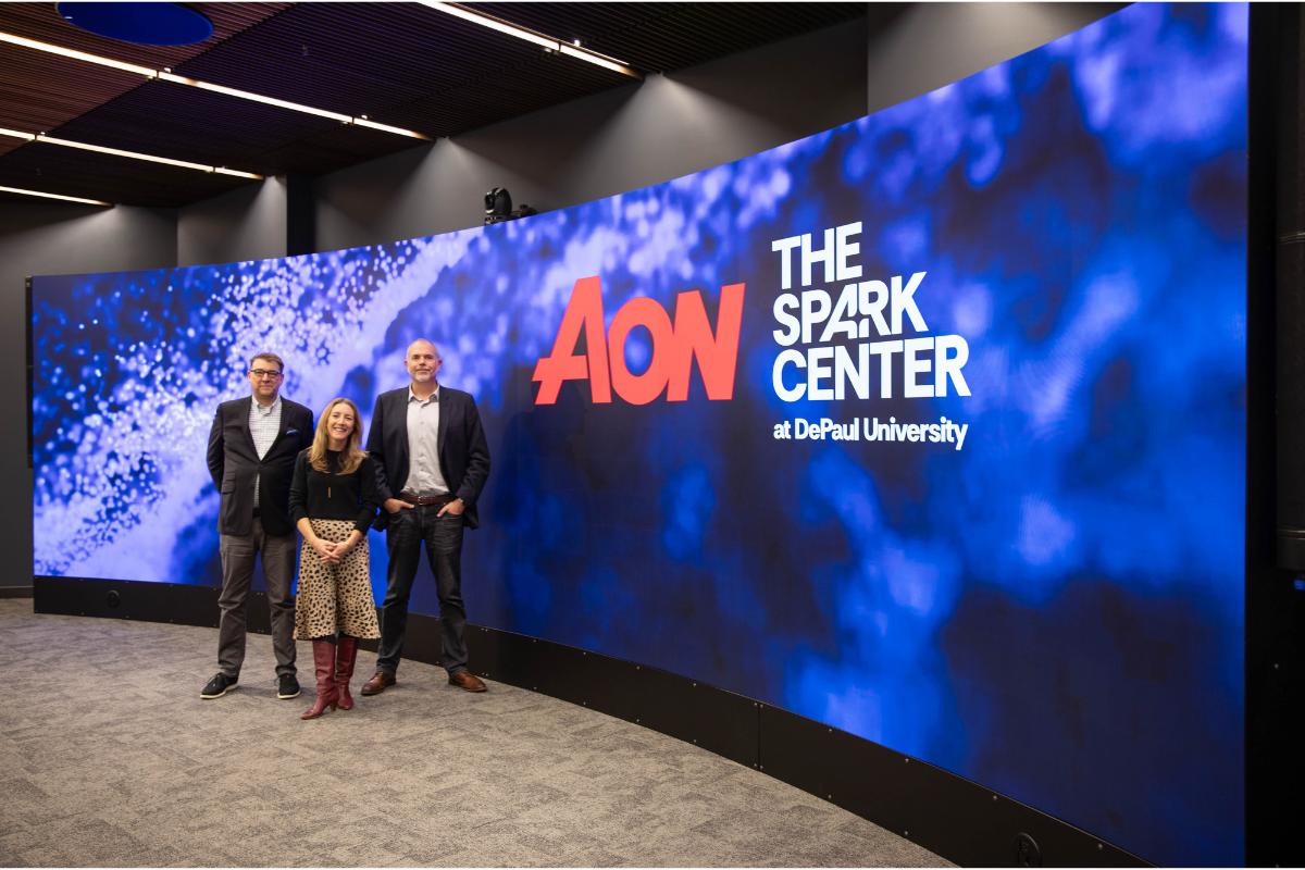 Photo of three people standing in front of screen