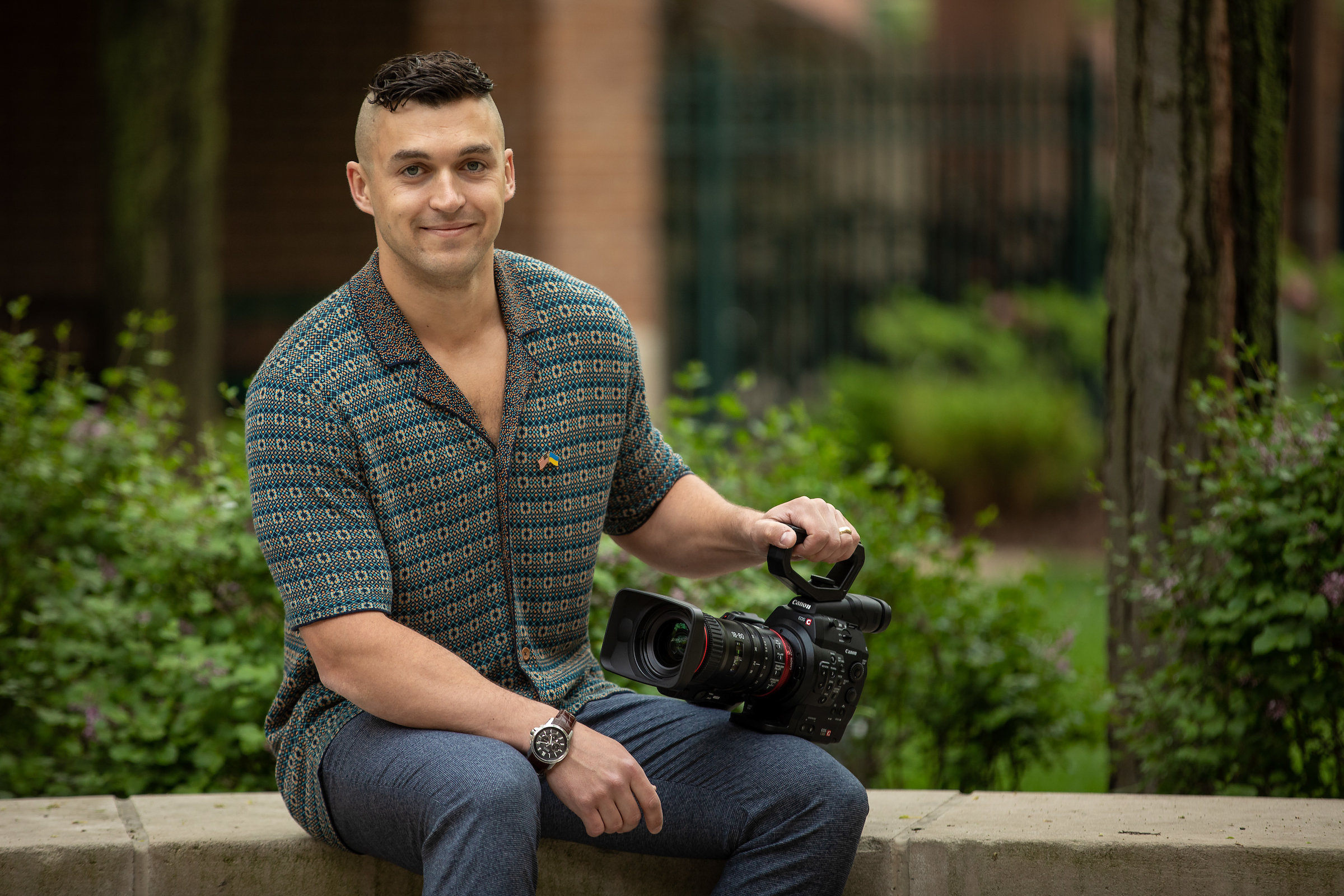 Mykhailo Bogdanov holds a video camera on the quad