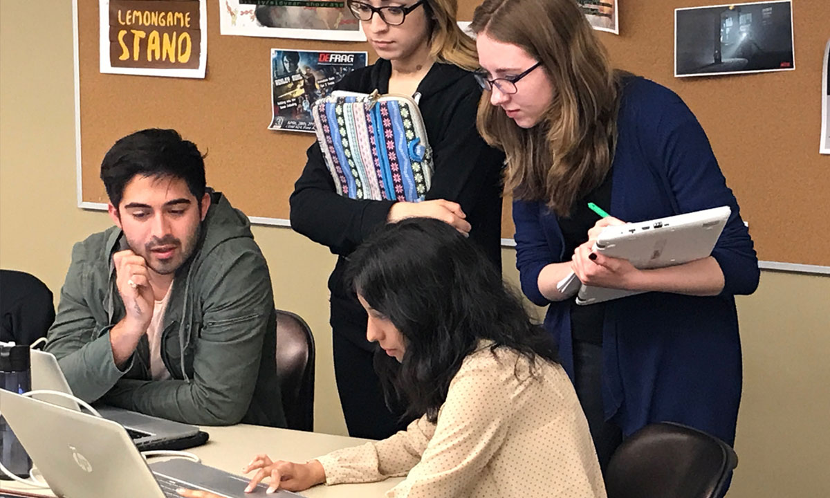 small group collorating infront of pc