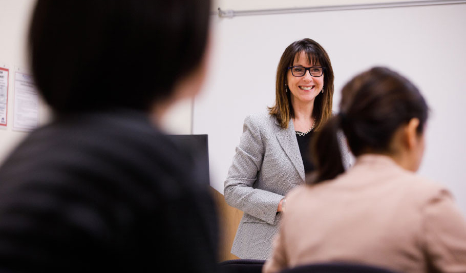 Distant shot of a faculty member smiling in a classroom