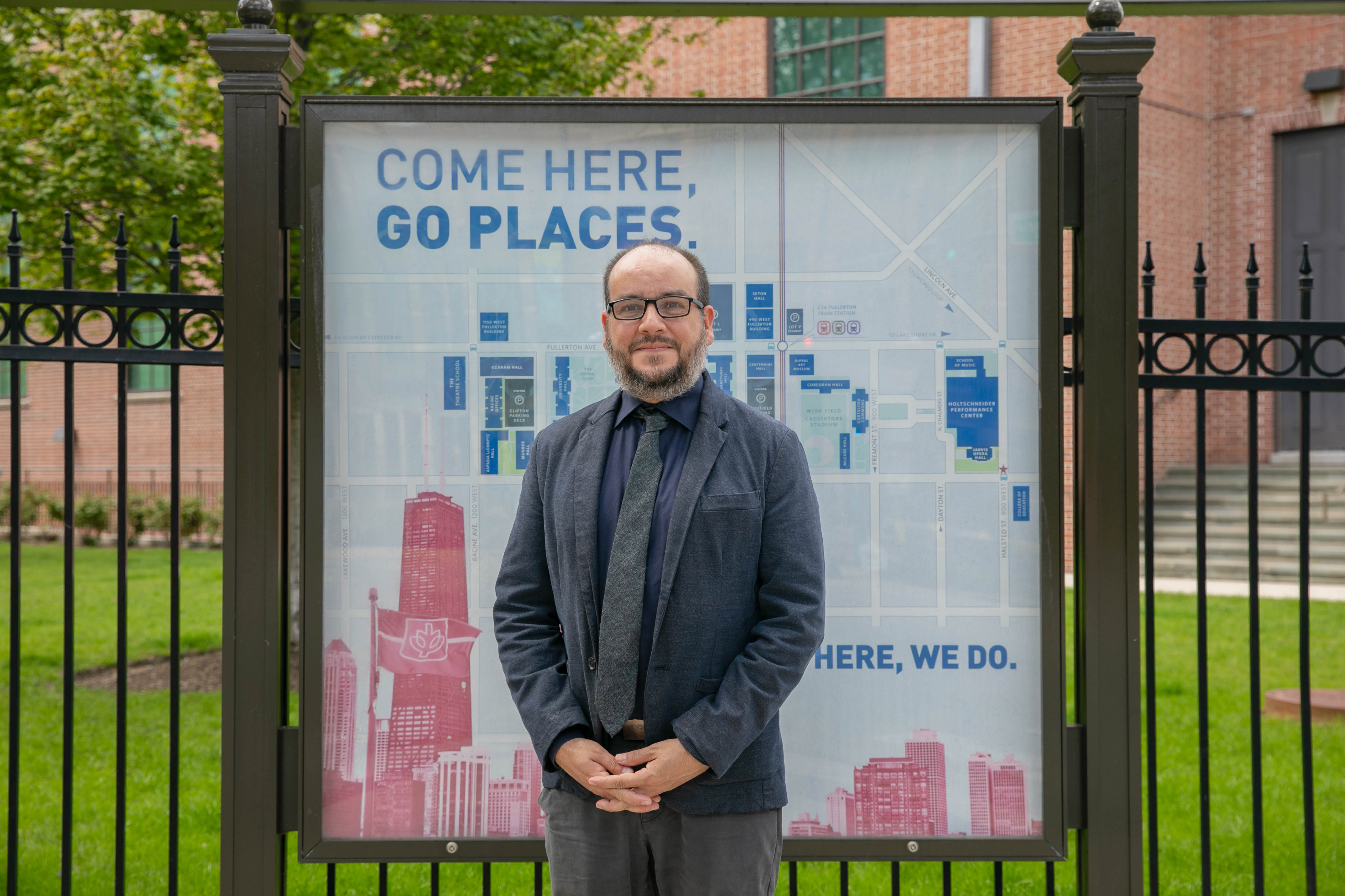 Fernando DeMaio in front of a DePaul sign