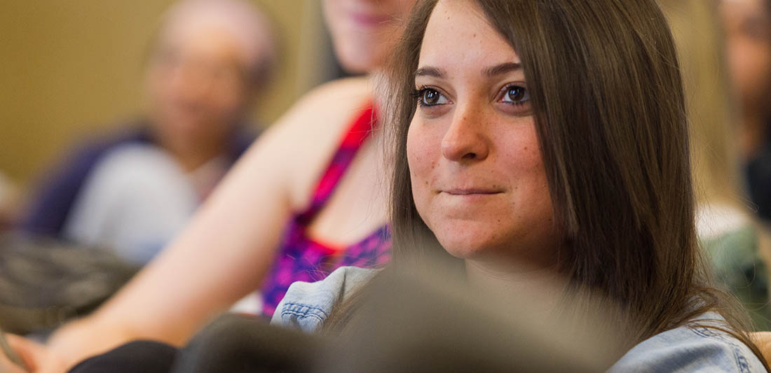 Focused shot of a student smiling in a classroom