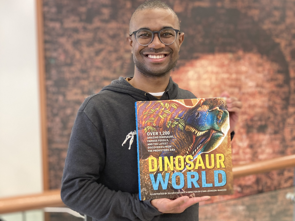 Evan Johnson-Ransom holding his book, Dinosaur World