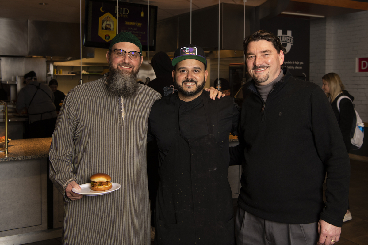 Three men standing together arm in arm