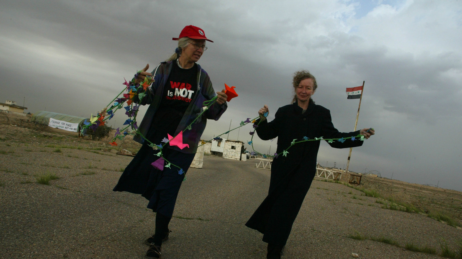 Kathy Kelly hanging peace cranes at the border with Kuwait.
