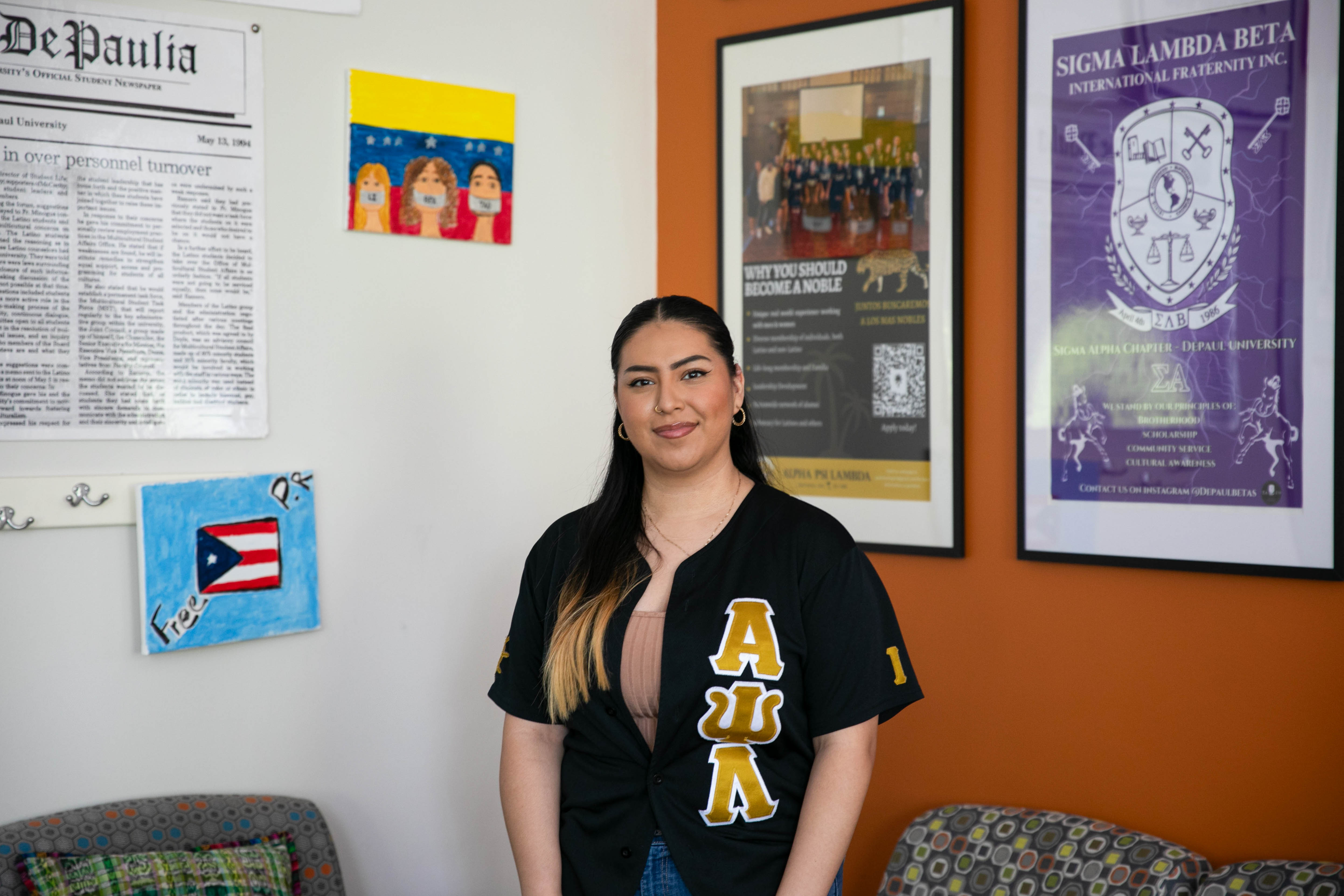 Jocelyn Torres-Barbosa standing in the Latinx Cultural Center wearing a top with her fraternity letters