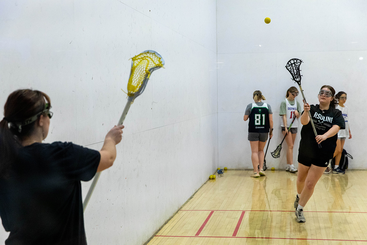 Two lacrosse players pass the ball