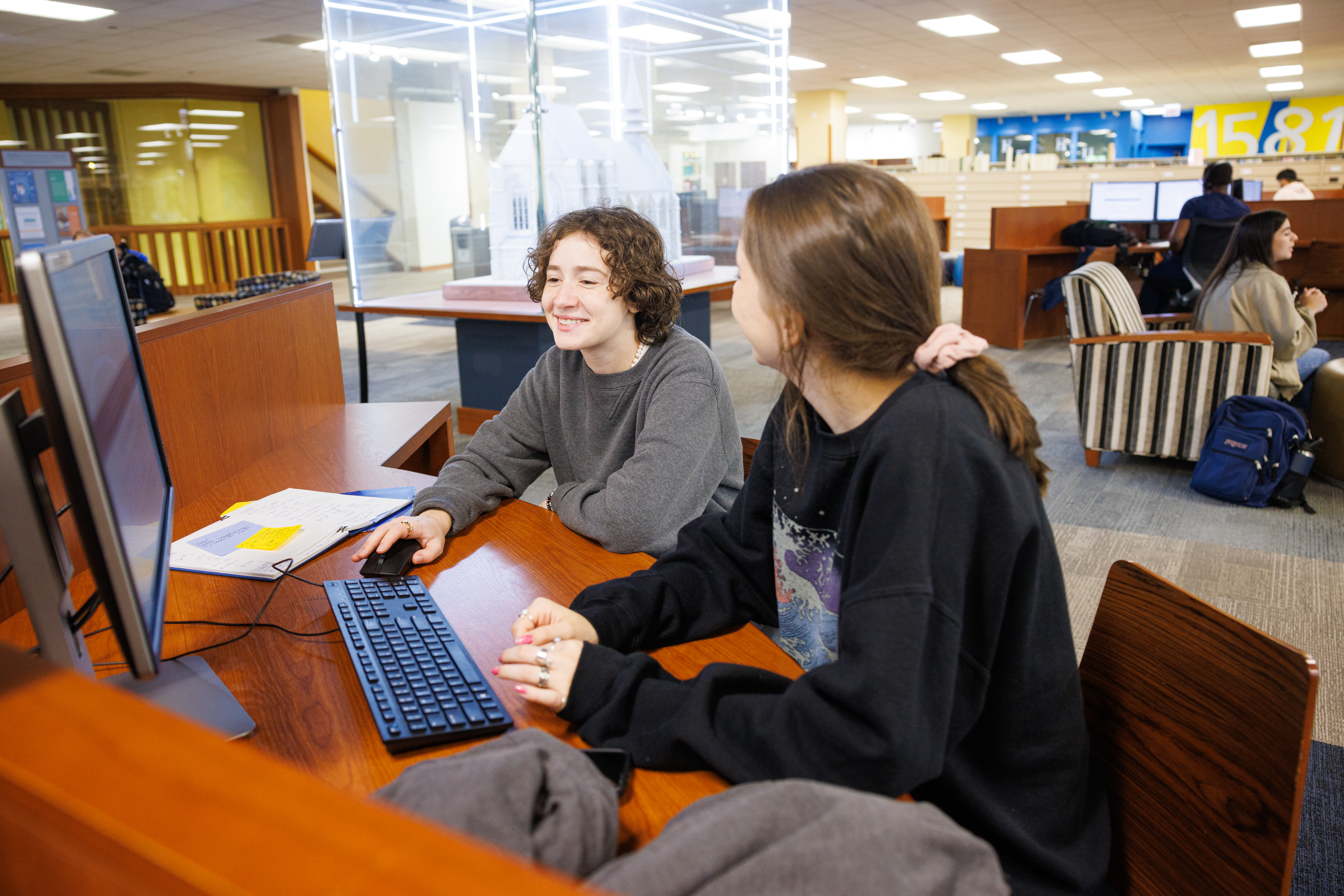 Students in library sitting by table at the Richardson DePaul location