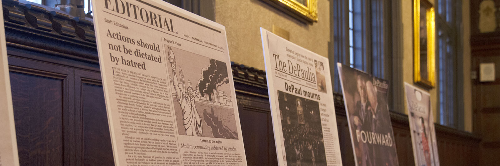 Photo of several large DePaulia front pages mounted on easels