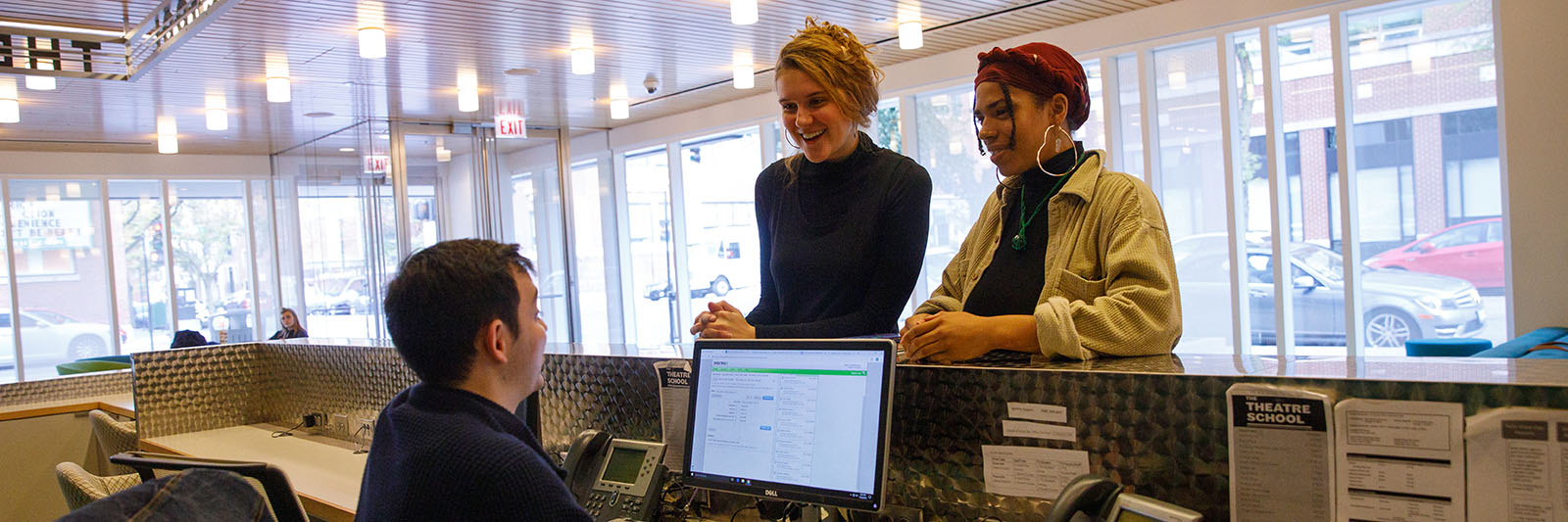 A theatre management student works at the box office.