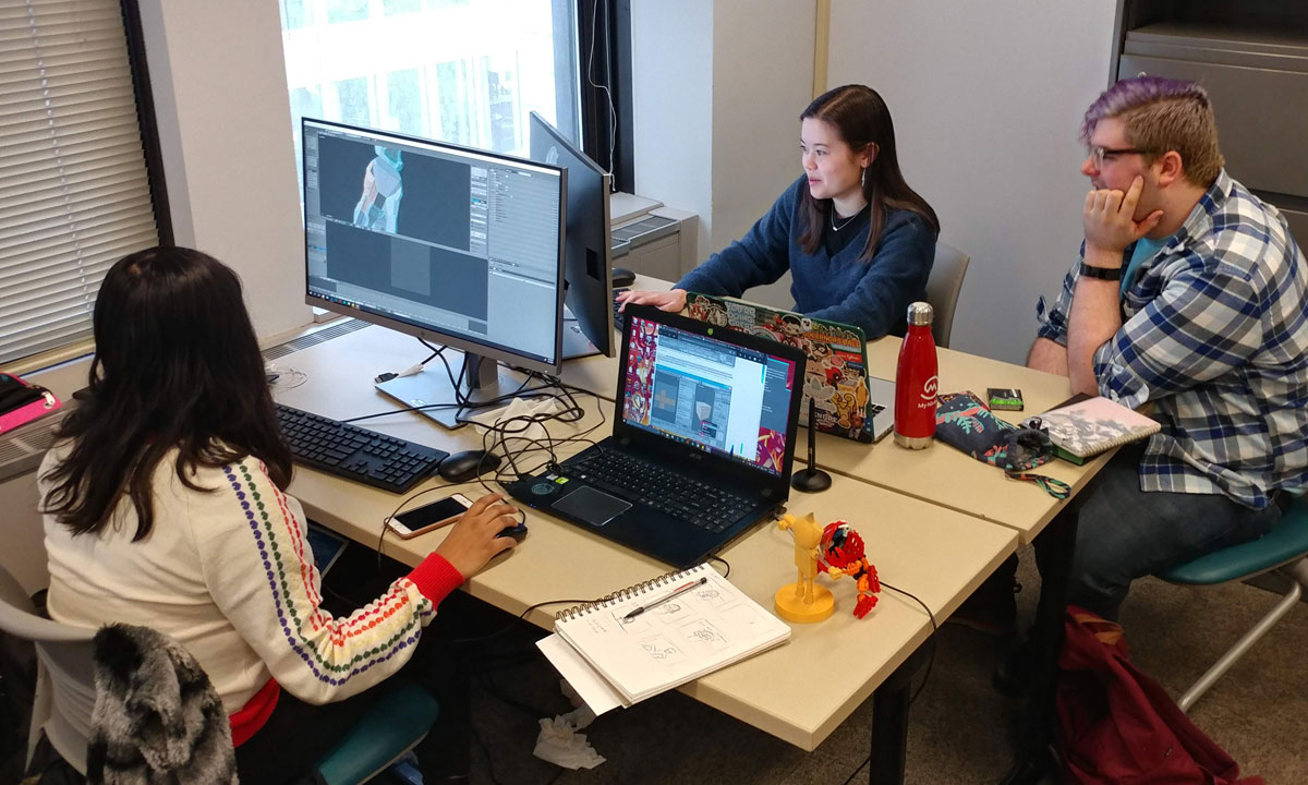 three students around a table working