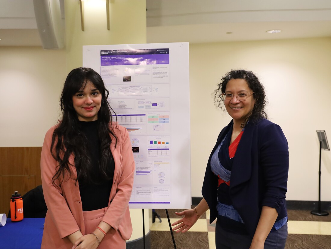 Professor and student presenting research poster
