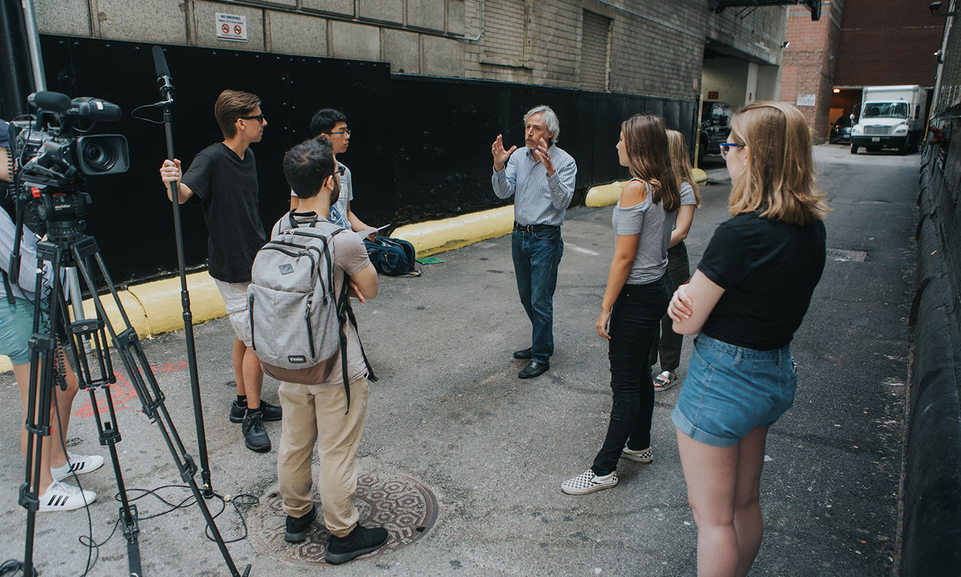 students in alley with film equipment