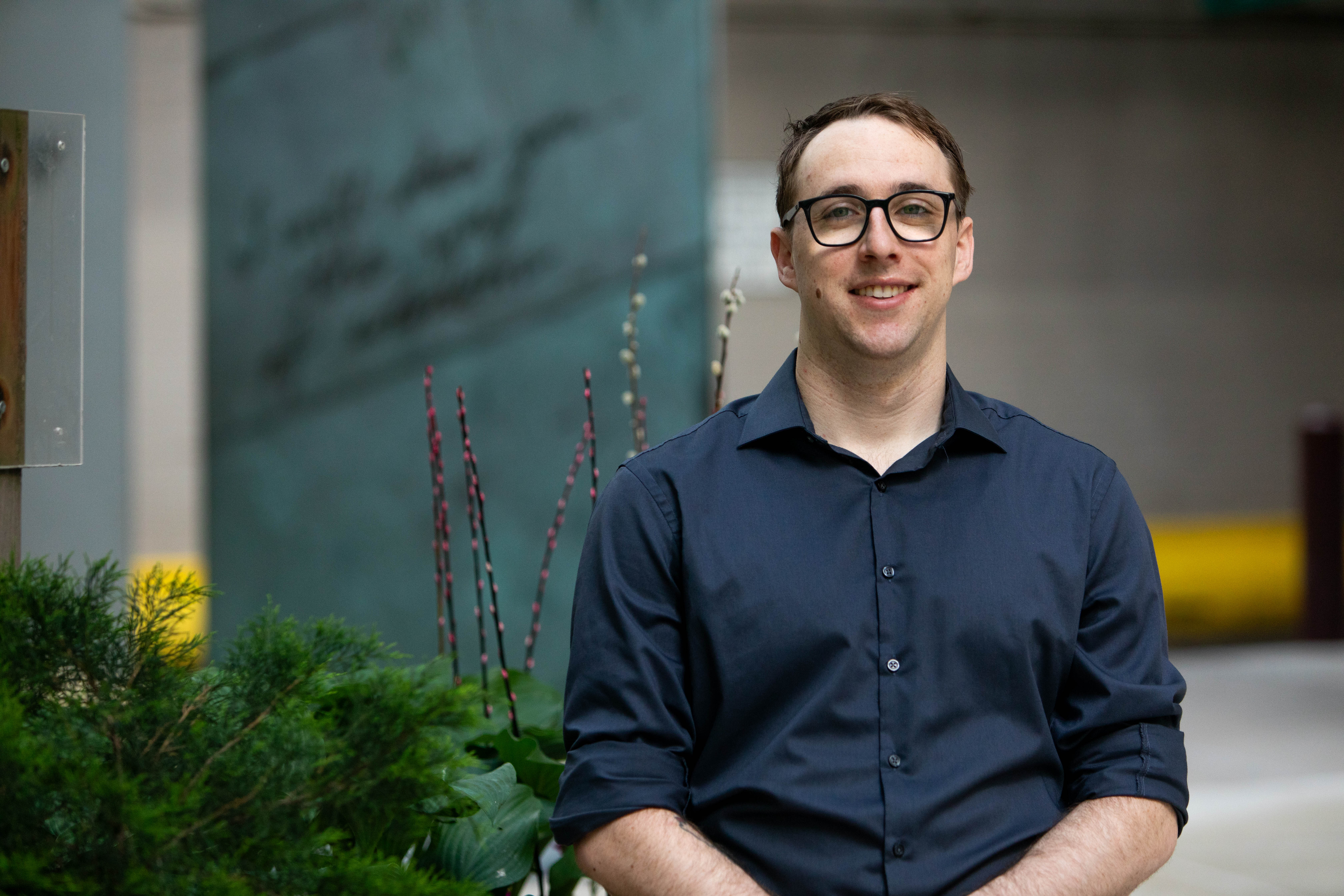 Matthew is standing by the plants