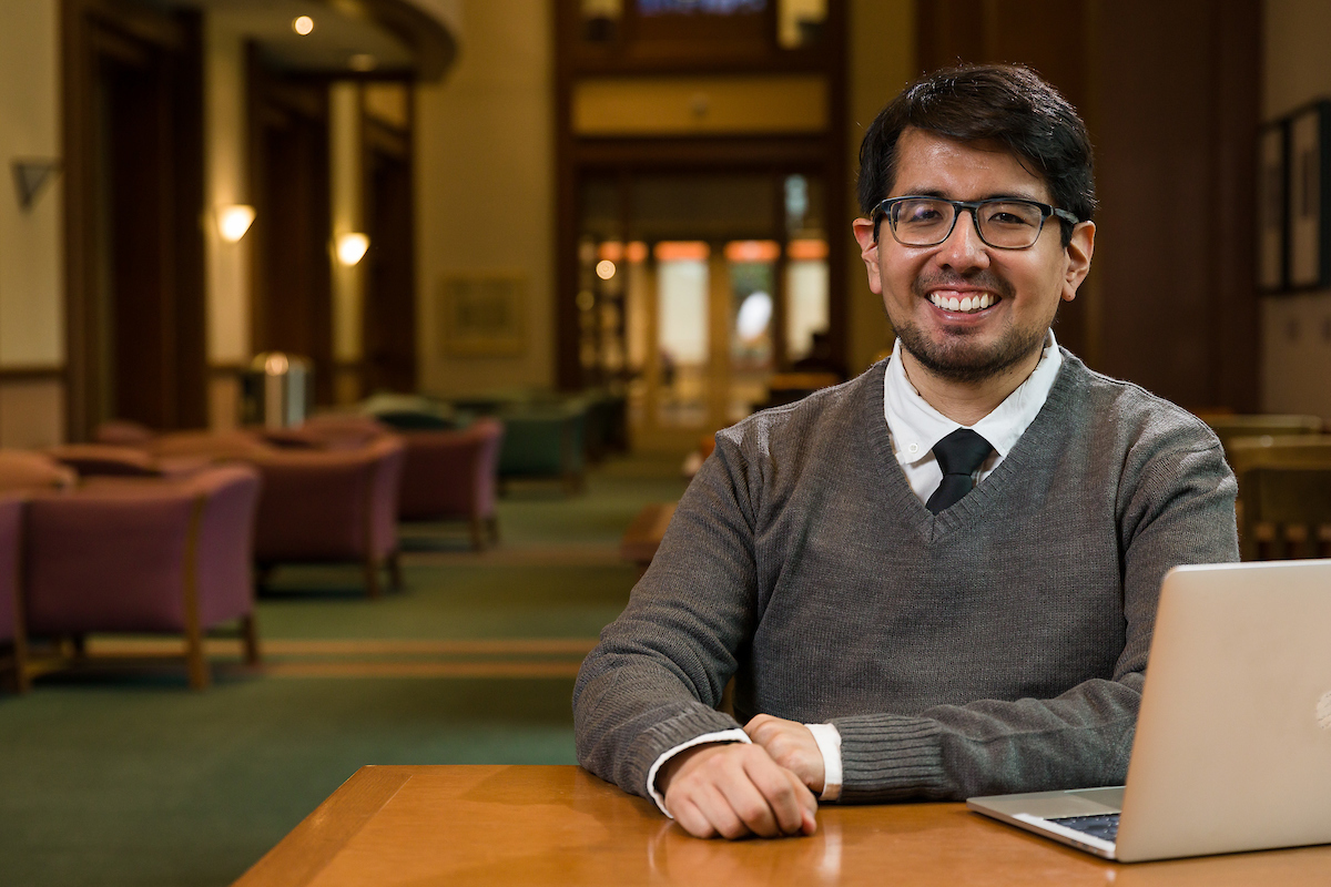 Julian Aparicio-Gomez sitting with a laptop