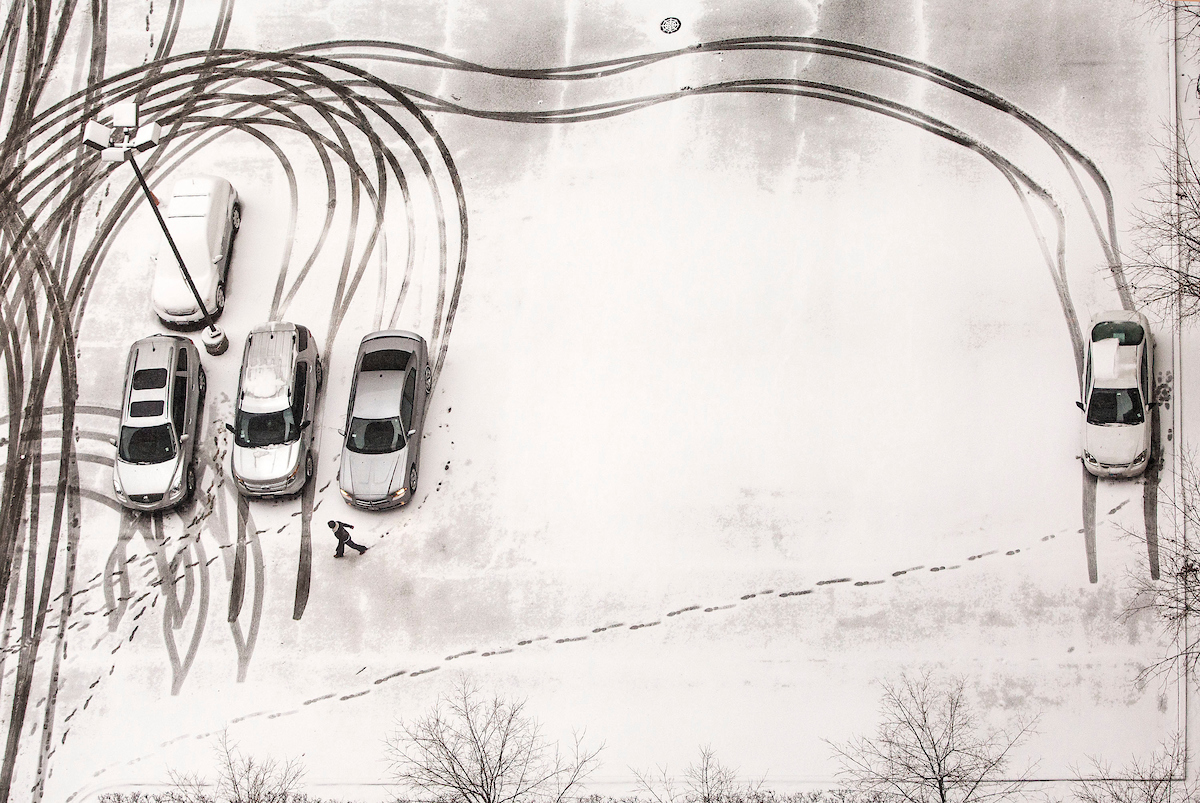 Cars parked in a snow covered lot.