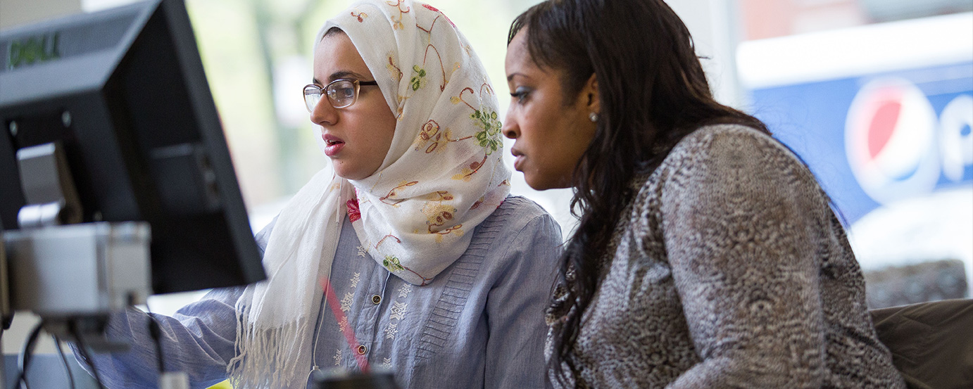 Two students looking at a computer together